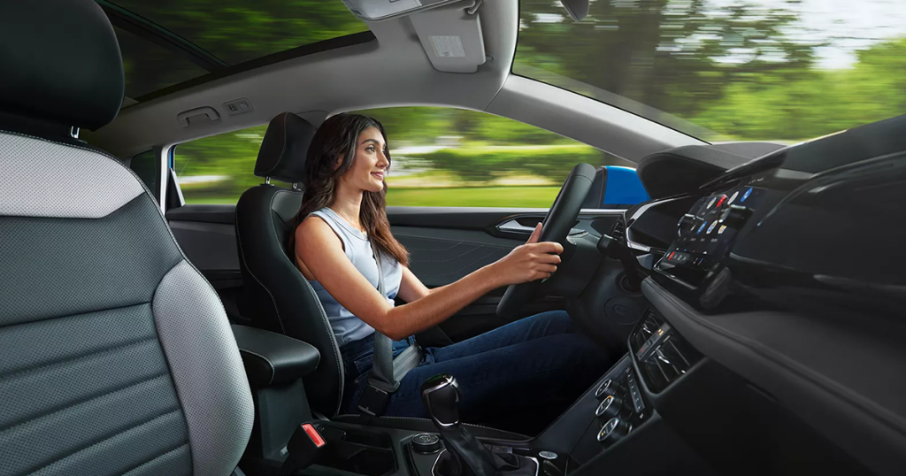 Woman driving inside of a 2024 Volkswagen Taos with grey and black cloudtex and cloth interior.