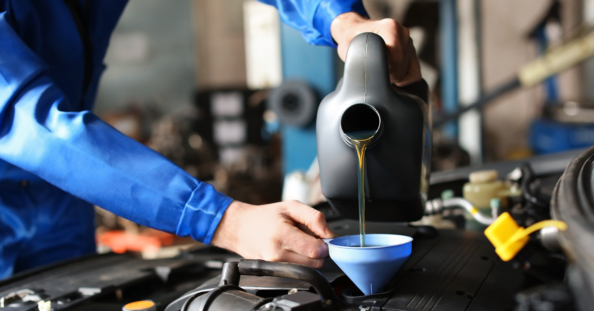 Close-up of a service technician performing an oil change service.
