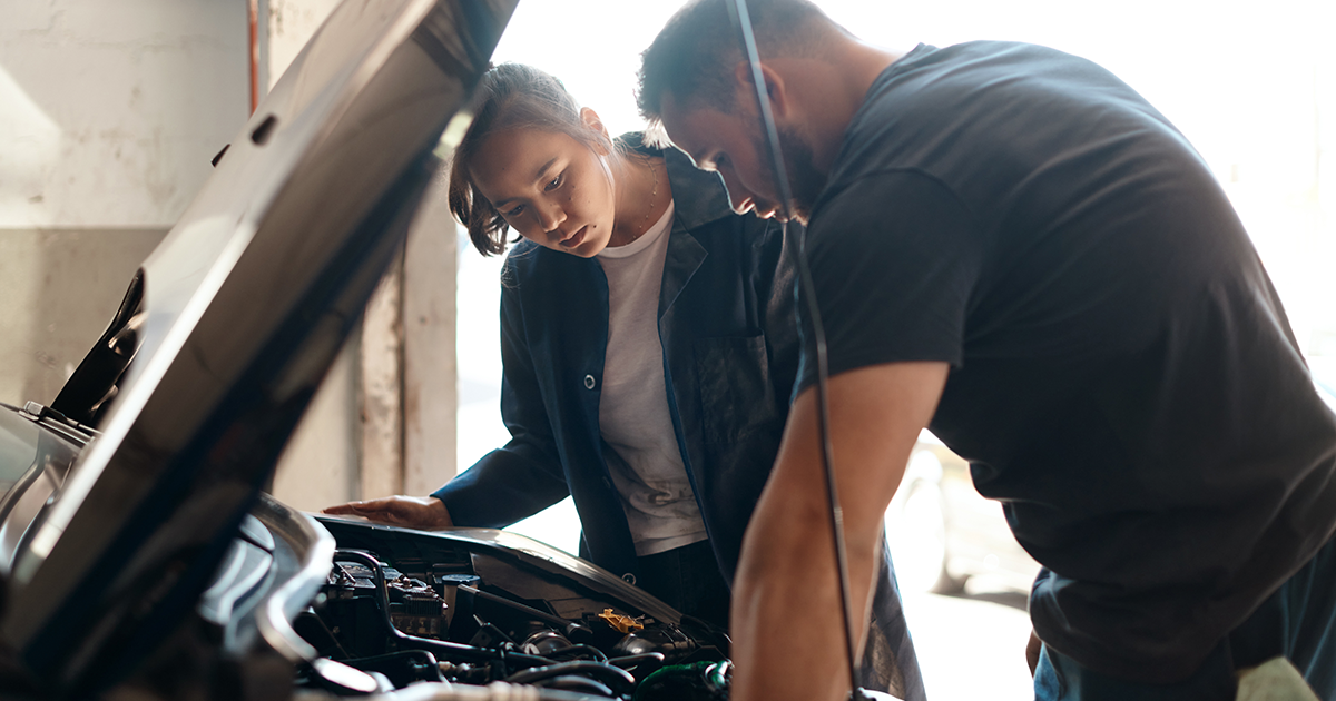 A mechanic helping a customer service their vehicle.